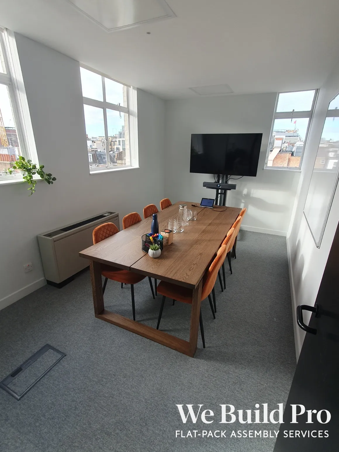 Executive meeting room with wooden table, city views and wall-mounted TV
