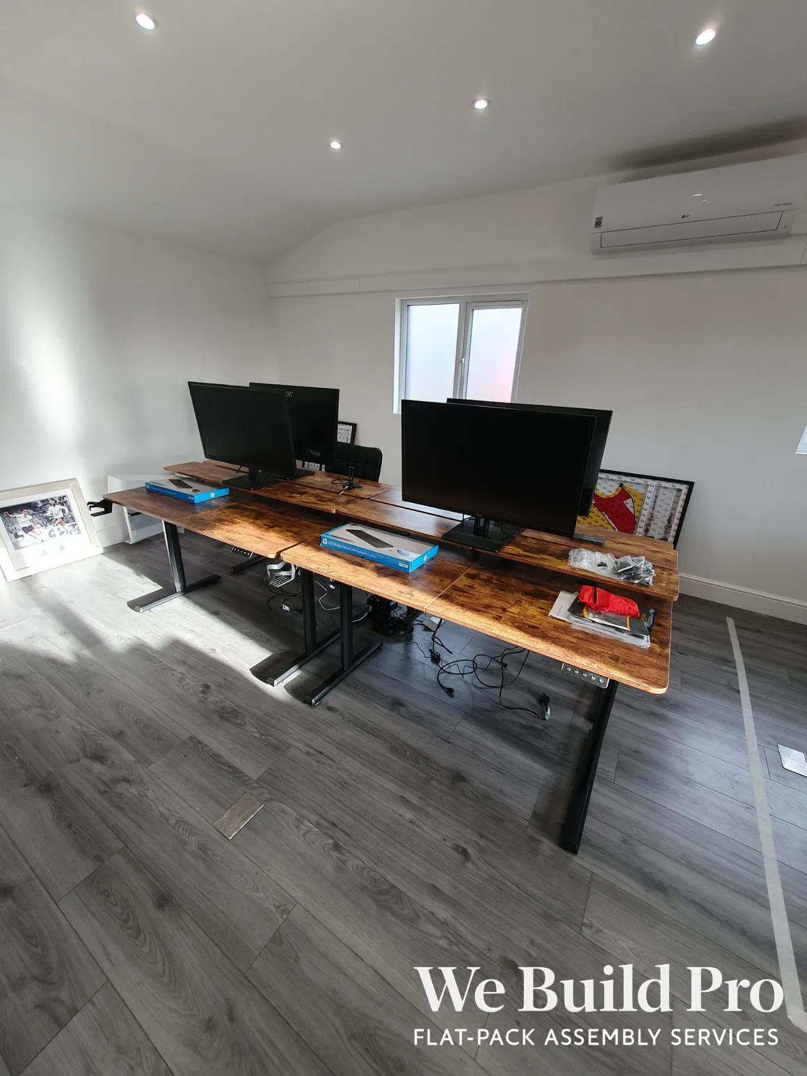 Modern office setup with dual monitor workstations and wooden desk