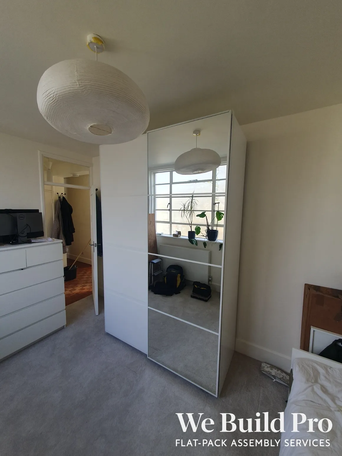 Modern sliding mirrored wardrobe in bedroom with pendant lighting