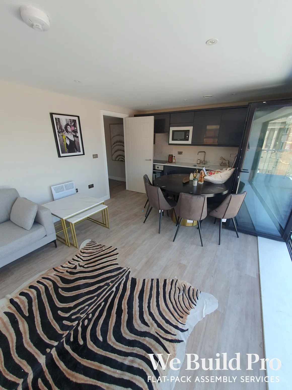 Modern apartment with open plan kitchen, dining area and zebra print rug