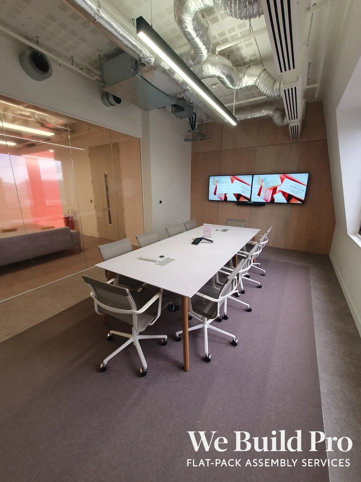 Executive conference room with modern AV setup and exposed ceiling